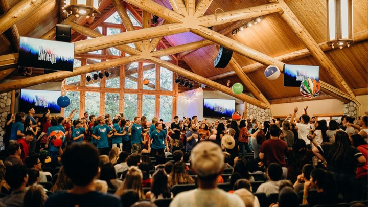 A full chapel with students standing during worship.