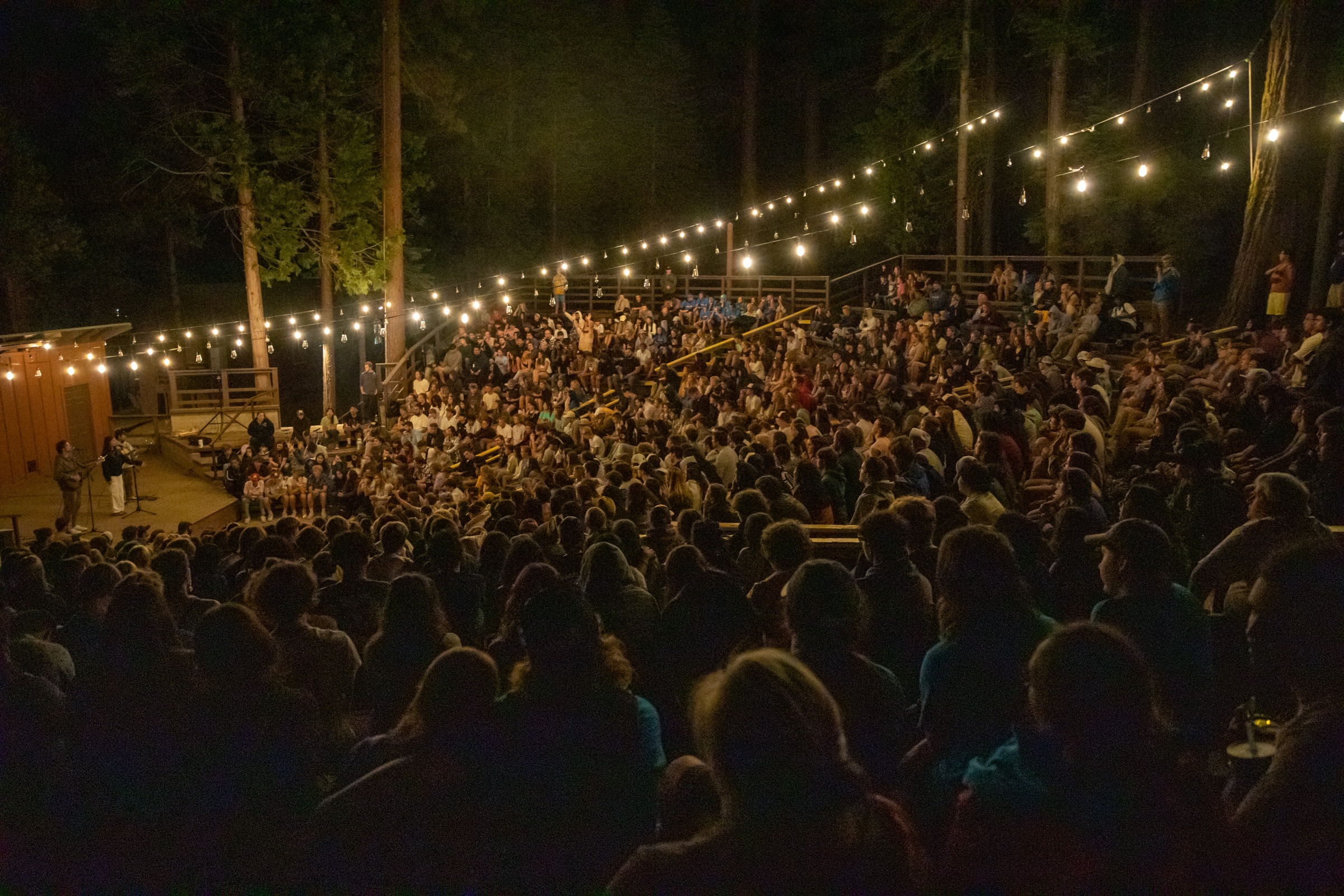 Evening worship at Ponderosa under string lights.